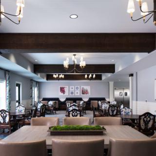 A spacious dining room with elegant chandeliers and stylish furniture.
