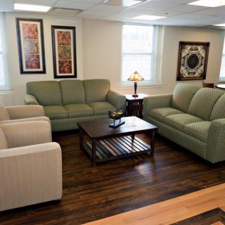 A cozy living room with sofas, armchairs, and a coffee table.
