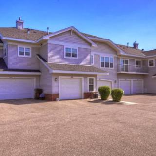 A view of a modern residential apartment complex featuring garages and well-maintained landscaping.