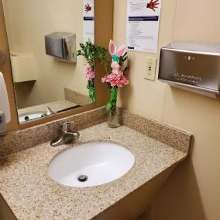 A clean and organized bathroom sink area with decorative flowers.