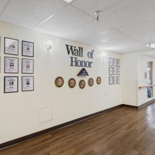 A hallway featuring a Wall of Honor with photos and plaques.