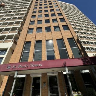 A tall urban hotel building with a distinctive glass and brick facade.