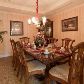 A traditional dining room with an elegant table setting under a chandelier.