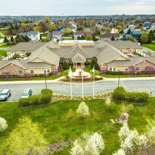 Aerial view of a suburban building surrounded by greenery and roads.