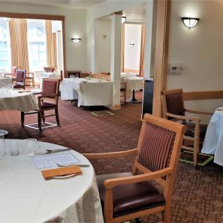 An empty restaurant dining room with neatly arranged tables and chairs.