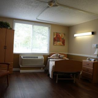 A cozy room featuring a bed, furniture, and natural light from the window.
