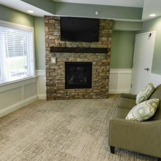 Cozy living room with a stone fireplace and mounted TV.