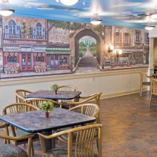 A cozy dining area featuring wicker furniture and a vibrant wall mural that adds character to the space.