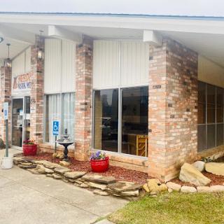 A charming brick building with a welcoming entrance and landscaped surroundings.