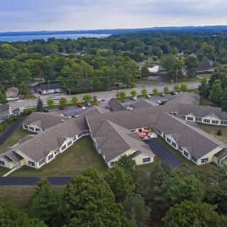 Aerial view of a large building complex surrounded by trees and roads.