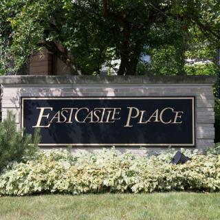 Outdoor sign for Eastcastle Place surrounded by greenery.