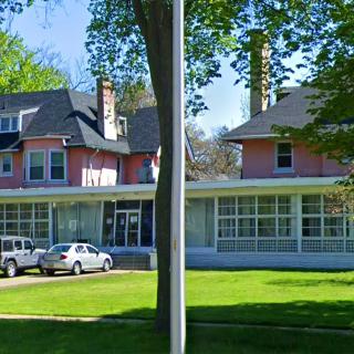 A large residential building with trees and parked cars in front, surrounded by a well-kept lawn.
