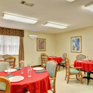 A cozy dining room with red tablecloths and neatly arranged tables.