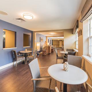 A cozy lounge area featuring modern furniture and a calming blue color scheme.