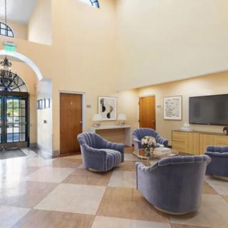 A modern lobby with comfortable seating, a television, and elegant decor.