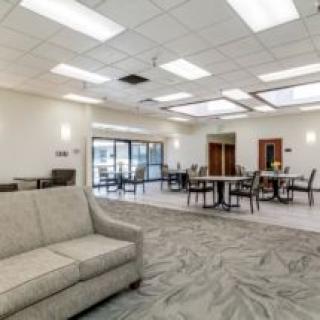 A modern lounge area with comfortable seating, tables, and bright lighting.