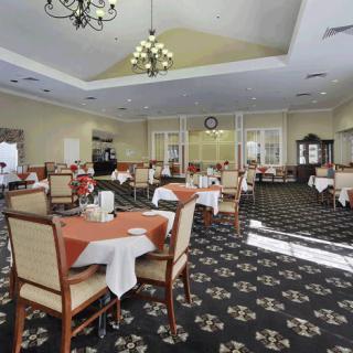 Elegant dining room with neatly arranged tables and a chandelier.