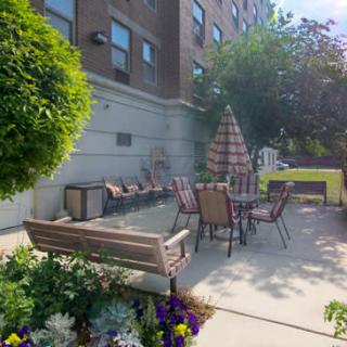 A cozy outdoor patio area with seating and vibrant flowers.