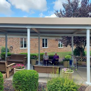 Two individuals enjoy a peaceful moment in a well-maintained outdoor area.