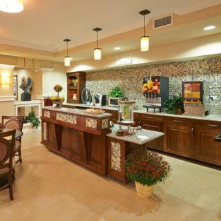 A modern kitchen and dining area with stylish lighting and wooden furniture.
