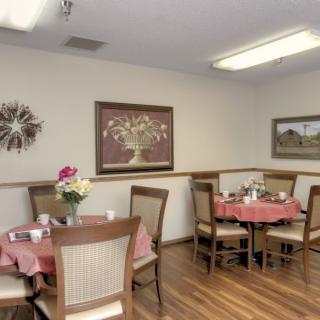 A cozy dining area with decorated tables and artwork on the walls.