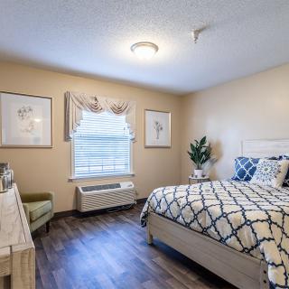 A cozy bedroom with a patterned bedspread and elegant decor.