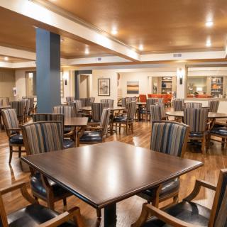 A spacious dining area with multiple tables and chairs arranged neatly.