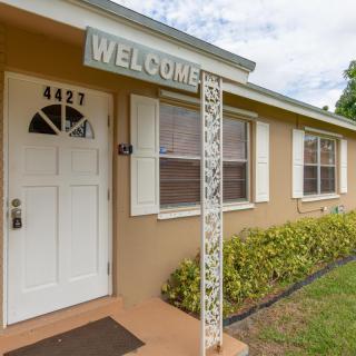A welcoming front entrance of a house with a 'Welcome' sign and address number 4427.