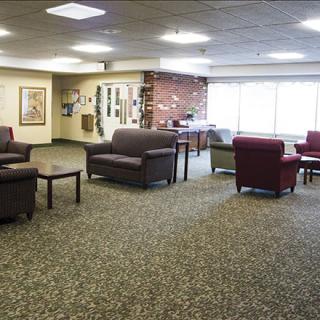 A well-lit lobby area with comfortable seating arrangements and a carpeted floor.