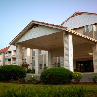 Front view of a hotel with landscaped greenery.
