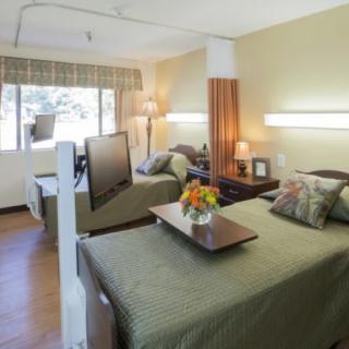 A well-organized hospital room featuring two beds and comfortable furnishings.