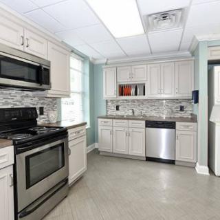 A modern kitchen featuring white cabinets, stainless steel appliances, and a stylish tile backsplash.