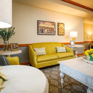 A cozy living room featuring a yellow couch with modern decor elements and warm lighting.