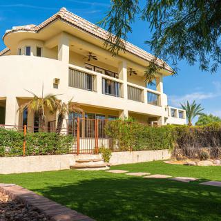 A luxurious residential house with a well-manicured garden and modern architecture.