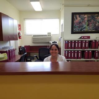 A friendly reception area with a welcoming woman at the front desk.
