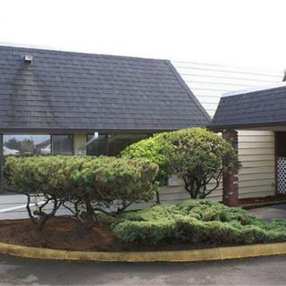 A suburban house with well-maintained landscaping and a sloped roof.