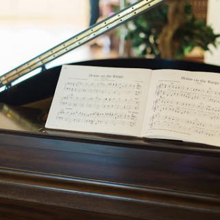 A close-up view of a piano with open sheet music, ready for a performance.