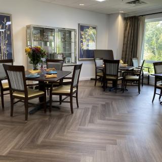 A modern dining area with wooden flooring and comfortable seating.