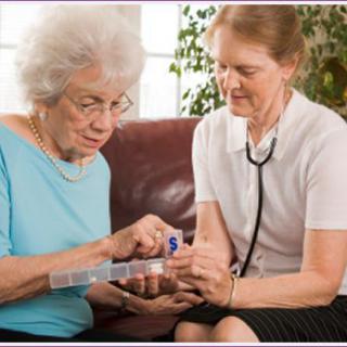 A nurse assisting an elderly woman with her medication during a home visit.