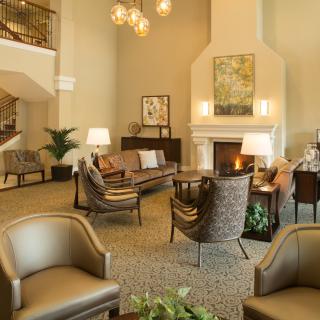 A cozy hotel lobby featuring comfortable seating, a warm fireplace, and elegant decor.