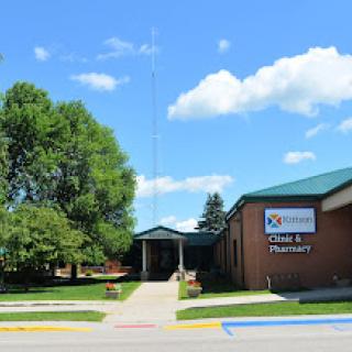 A sunny day view of a pharmacy building with a welcoming entrance.