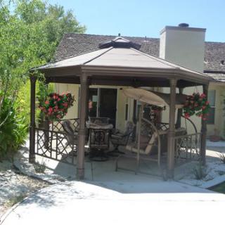A cozy outdoor gazebo with seating and hanging plants, perfect for relaxation.