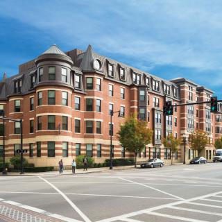 A large brick residential building at a city street intersection.