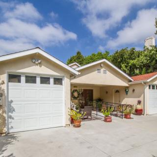 A residential house with a garage and driveway on a sunny day.