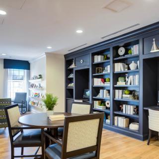 A cozy reading area with a large bookshelf and comfortable seating.