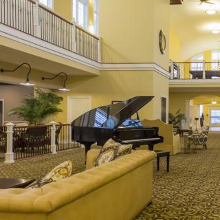 A spacious lobby with a grand piano and comfortable seating.