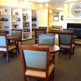 A cozy library seating area with tables, chairs, and bookshelves.
