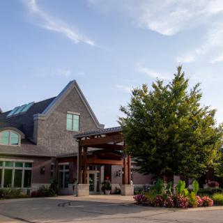 A modern hospitality building with beautiful landscaping under a clear sky.