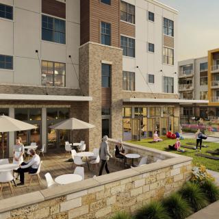 A modern building with an outdoor seating area where people are enjoying their time on the patio.