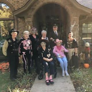 A group of friends dressed in various costumes, celebrating Halloween outdoors.